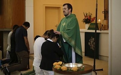 Pastor Gottfried Martens prays with people from Iran during a baptism service in the Trinity Church in Berlin, Aug. 30, 2015.  (AP/Markus Schreiber)