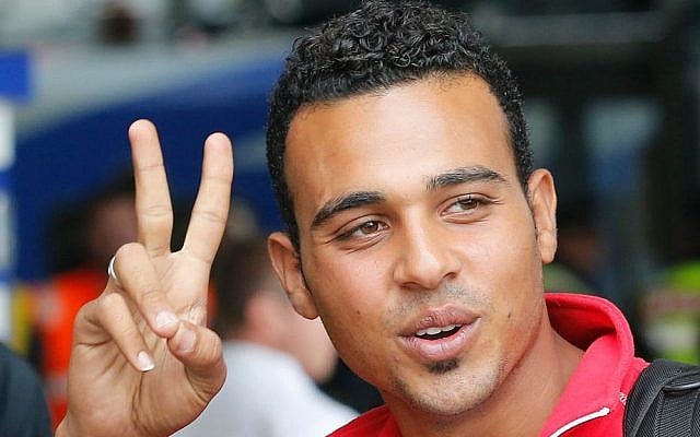 A young migrant flashes a victory sign as he arrives at the main train station in Munich, Germany, Saturday, Sept. 5, 2015. (AP Photo/Michael Probst)