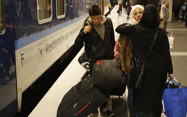 In this Sept. 16, 2015 photo Reem Habashieh is hugged as she says good-bye to a friend as she and her younger brother Yaman, board a train in Berlin that brings them to Dresden from where they continued their journey to Chemnitz. On Tuesday afternoon, the family _44-year-old Khawla Kareem, her daughters Reem, 19, and Raghad, 11, and sons Mohammed, 17, and Yaman, 15 _ finally got their papers, all stamped, with passport photos, a new address and train tickets to go to Chemnitz, a city of 240,000 near the Czech border. (AP/Ferdinand Ostrop)