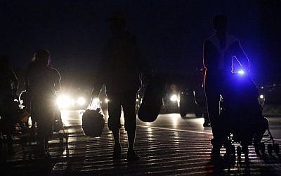 People carry their belongings as they walk in a long line out of Budapest, Hungary, Friday, Sept. 4, 2015.  (AP/Frank Augstein) 
