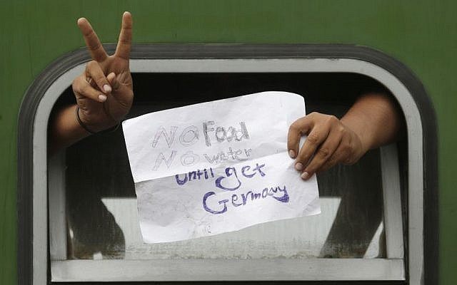 A man displays a sign out of a window of a train that was stopped in Bicske, Hungary, Sept. 4, 2015. (AP/Petr David Josek)