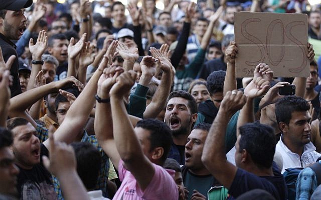 Migrants shout slogans in front of the Keleti Railway Station in Budapest, Hungary, Wednesday, Sept. 2, 2015, as hundreds demanded to be let on trains to Germany. (AP Photo/Petr David Josek)