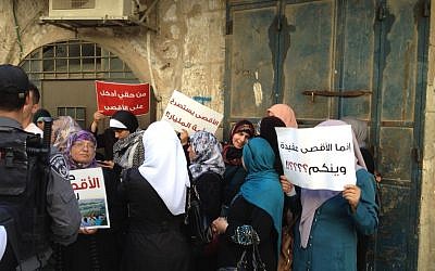 Murabitat activists hold signs reading 'it is my right to enter al-Aqsa' and 'al-Aqsa cries out to the nation of one billion,' September 2, 2015 (Elhanan Miller/Times of Israel) 