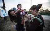 IsraAID volunteers deliver baby slings to Syrian and Afghan refugees on the Hungarian-Serbian border, September 15, 2015. (Photo: IsraAID)