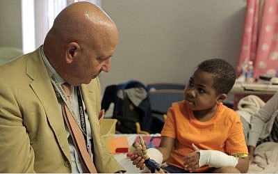 Dr. L. Scott Levin in a post-op visit with 8-year-old Zion Harvey, who underwent a bilateral hand transplant in July 2015 at the Children's Hospital of Philadelphia. (courtesy CHOP)