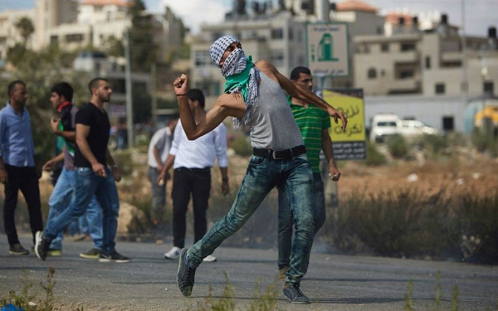 A Palestinian demonstrator hurls a stone during clashes with Israeli troops near Ramallah, Tuesday, Sept. 29, 2015. (AP Photo/Majdi Mohammed)