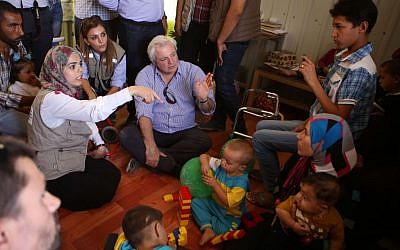 UN humanitarian chief Stephen O'Brien, center, visits with Syrian refugees who fled civil war in their country, in the Zaatari Refugee Camp, near Mafraq, Jordan, Saturday, Sept. 19, 2015.  (AP Photo/Raad Adayleh)