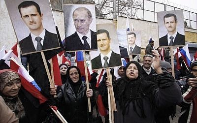 In this Sunday, March 4, 2012 file photo, Syrians hold posters of Syrian President Bashar Assad, far left, and Russian President Vladimir Putin, second left, during a pro-Syrian government protest in front of the Russian Embassy in Damascus, Syria. (AP/Muzaffar Salman, File)