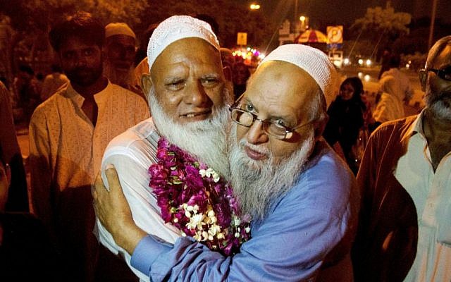 A Pakistani man receives his family member who returned from Saudi Arabia after the hajj pilgrimage, at Karachi airport, Pakistan, Monday, Sept. 28, 2015. (AP Photo/Shakil Adil)