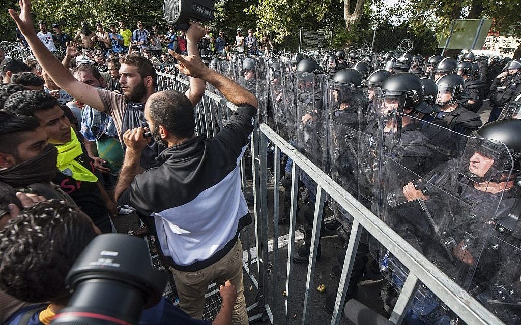 Migrants demonstrate at the 'Horgos 2' border crossing into Hungary, near Horgos, Serbia, Wednesday, September 16, 2015. (Sandor Ujvari/MTI via AP)