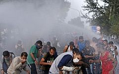 Hungarian police spray water on migrants at the 'Horgos 2' border crossing into Hungary, near Horgos, Serbia, Wednesday, September 16, 2015. (AP Photo/Darko Vojinovic)