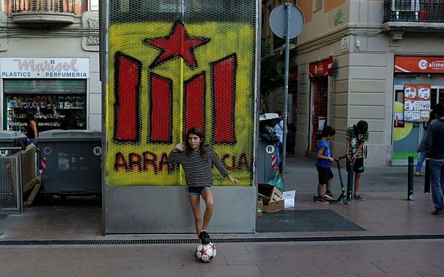 In this photo taken Tuesday, Sept. 8, 2015, a young girl plays with a ball in front of a graffiti of an Estelada flag (pro-independence Catalan flag) in Barcelona. (AP Photo/Manu Fernandez) In this photo taken Tuesday, Sept. 8, 2015, a young girl plays with a ball in front of a graffiti of an Estelada flag (pro-independence Catalan flag) in Barcelona. (AP Photo/Manu Fernandez)