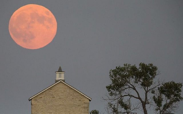 A super moon rises over the Lower Fox Creek School near Strong City, Kan., Sunday, Sept. 27, 2015. It was the first time Sunday since 1982 that a total lunar eclipse was combined with a supermoon. (Travis Heying/The Wichita Eagle via AP) A super moon rises over the Lower Fox Creek School near Strong City, Kan., Sunday, Sept. 27, 2015. It was the first time Sunday since 1982 that a total lunar eclipse was combined with a supermoon. (Travis Heying/The Wichita Eagle via AP)