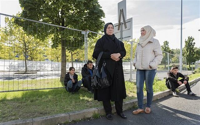 From left, Raghad, Mohammed, mother Khawla Kareem, Reem and Yaman, a refugee family from Syria, wait outside an asylum seekers shelter in Heidenau, near Dresden, eastern Germany, Sept. 22, 2015 photo (AP Photo/Matthias Rietschel) From left, Raghad, Mohammed, mother Khawla Kareem, Reem and Yaman, a refugee family from Syria, wait outside an asylum seekers shelter in Heidenau, near Dresden, eastern Germany, Sept. 22, 2015 photo (AP Photo/Matthias Rietschel)