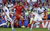 Wales’s Gareth Bale, center, breaks between Israel’s Bibras Natcho, left, and Orel Dgani during the Euro 2016 Group B qualifying match between Israel and Wales at the Cardiff City stadium in Cardiff, Wales, Sunday, September 6, 2015. (Tim Ireland/AP)