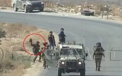 A still image taken from footage shot in the West Bank on September 25, 2015 apparently shows an IDF soldier hurling a camera belonging to AFP reporters to the ground. (screen capture: YouTube)