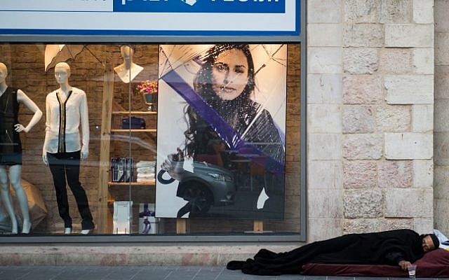 A homeless man sleeping in front of a department store in Jerusalem on December 4, 2014. (Danielle Shitrit/Flash90) A homeless man sleeping in front of a department store in Jerusalem on December 4, 2014. (Danielle Shitrit/Flash90)