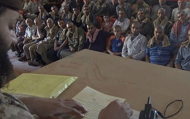 Islamic State officials are making Christians in the Syrian town of Al-Qaryatayn sign a contract for non-Muslims, in an image released September 3, 2015. (Photo credit: MEMRI) Islamic State officials are making Christians in the Syrian town of Al-Qaryatayn sign a contract for non-Muslims, in an image released September 3, 2015. (Photo credit: MEMRI)