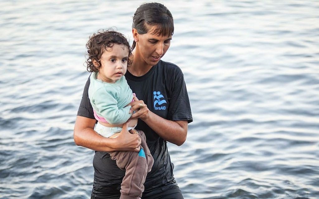 Tali Shaltiel, an Israeli physician, taking a Syrian child from a dinghy that arrived at a beach on the Greek island of Lesbos. (Boaz Arad/IsraAID) Tali Shaltiel, an Israeli physician, taking a Syrian child from a dinghy that arrived at a beach on the Greek island of Lesbos. (Boaz Arad/IsraAID)