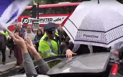 Metropolitan Police hold back pro-Palestinian demonstrators as a man waving an Israeli flag drives past, during rival protests outside Downing Street in London as Prime Minister Benjamin Netanyahu met with British counterpart David Cameron on September 9, 2015. (screen capture: YouTube)