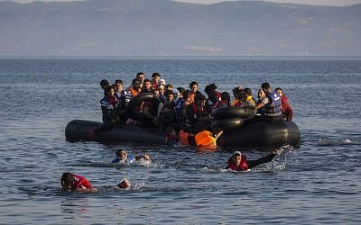 An illustrative image of migrants swimming from an overcrowded dinghy on July 27, 2015. (AP/Santi Palacios)