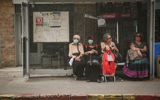 Israelis cover their mouths at a bus stop in Jerusalem on September 8, 2015. (Photo by Hadas Parush/Flash90) Israelis cover their mouths at a bus stop in Jerusalem on September 8, 2015. (Photo by Hadas Parush/Flash90)