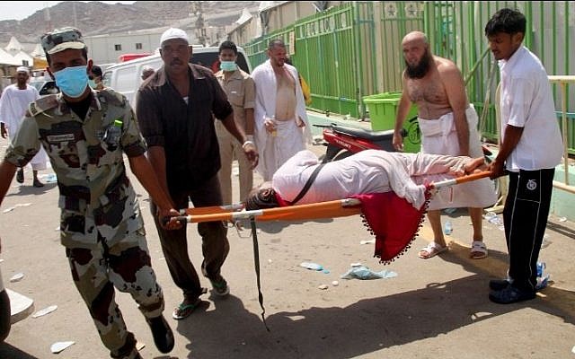 Hajj pilgrims and Saudi emergency personnel carry a woman on a stretcher at the site where hundreds were killed in a stampede in Mina, near the holy city of Mecca, at the annual hajj in Saudi Arabia on September 24, 2015. (AFP/STR)