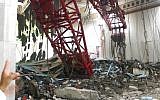 A pilgrim points at a crane that collapsed and killed dozens inside the Grand Mosque in Mecca, Saudi Arabia, Friday, Sept. 11, 2015.  (AP Photo)