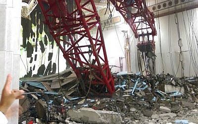 A pilgrim points at a crane that collapsed and killed dozens inside the Grand Mosque in Mecca, Saudi Arabia, Friday, Sept. 11, 2015.  (AP Photo)