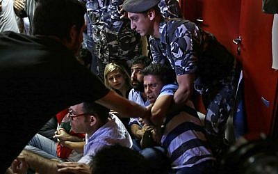 A Lebanese policeman, right, tries to drags away an anti-government activist during a sit-in protest against Environment Minister Mohammed Machnouk, inside the Environment Ministry, in downtown Beirut, Lebanon, Tuesday, September 1, 2015. (Hassan Ammar/AP)