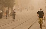 Israelis walk across the lightrail tracks on Jerusalem's Jaffa Road on September 8, 2015 during a sandstorm. (Yonatan Sindel/Flash90)