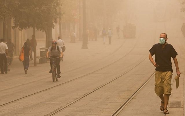 Israelis walk across the lightrail tracks on Jerusalem's Jaffa Road on September 8, 2015 during a sandstorm. (Yonatan Sindel/Flash90) Israelis walk across the lightrail tracks on Jerusalem's Jaffa Road on September 8, 2015 during a sandstorm. (Yonatan Sindel/Flash90)