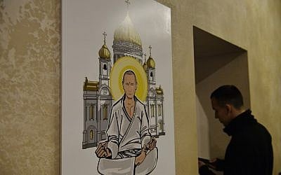 A visitor stands next to an artwork depicting Russian President Vladimir Putin as Buddha during the 'Putin Universe' exhibition in Moscow on October 6, 2015. (Natalia Kolesnikova/AFP)
