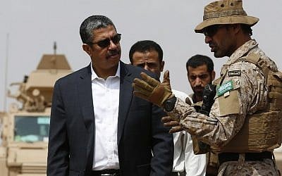 A member of the Saudi forces speaks to Yemeni Prime Minister Khaled Bahah (L) during his visit to the Saudi-led coalition military base  (AFP PHOTO / AHMED FARWAN)