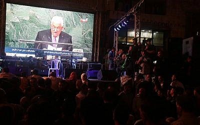 Palestinians watch the speech of PA President Mahmoud Abbas on a giant screen in Ramallah as he addresses the world at the United Nations headquarters in New York on September 30, 2015. (AFP/Jaafar Ashtiyeh)