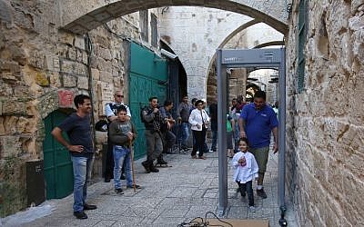 Tourists walk past a metal detector in the Muslim Quarter of Jerusalem's Old City on October 8, 2015 following a spate of knife attacks. (AFP Photo / Gali Tibon)