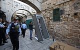 Israeli security forces stand guard as workers install a metal detector in the Muslim quarter of Jerusalem's Old City on October 8, 2015 following a spate of knife attacks. (Photo by AFP Photo / Gali Tibon)