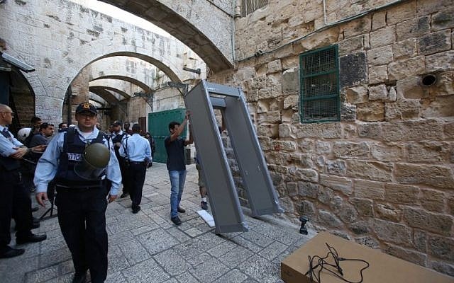 Israeli security forces stand guard as workers install a metal detector in the Muslim quarter of Jerusalem's Old City on October 8, 2015 following a spate of knife attacks. (Photo by AFP Photo / Gali Tibon)