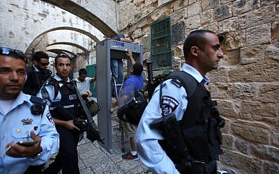 Israeli security forces stand guard as workers install a metal detector in the Muslim quarter of Jerusalem's Old City on October 8, 2015. (AFP/GALI TIBON)