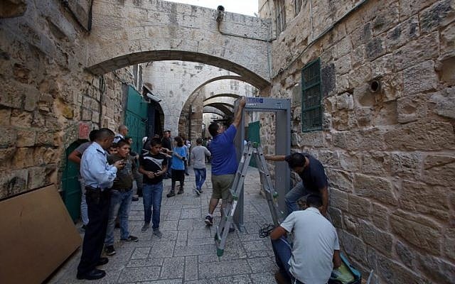 Israeli security forces stand guard as workers install a metal detector in the Muslim quarter of Jerusalem's Old City on October 8, 2015 following a spate of knife attacks. (Photo by AFP Photo / Gali Tibon)