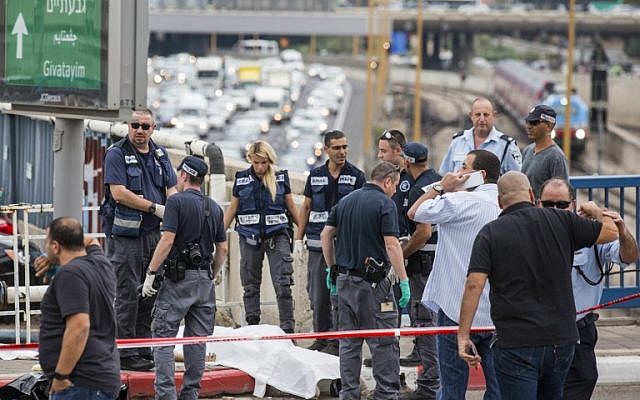 Israeli security forces inspect the body of a Palestinian man who was shot dead after carrying out a stabbing attack on an Israeli soldier and four passers-by in the coastal city of Tel Aviv, October 8, 2015. (AFP/JACK GUEZ)