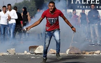 A Palestinian protester throws back a tear gas canister during clashes with Israeli soldiers at the Hawara checkpoint, south of the West Bank city of Nablus on October 9, 2015. (AFP PHOTO/JAAFAR ASHTIYEH) A Palestinian protester throws back a tear gas canister during clashes with Israeli soldiers at the Hawara checkpoint, south of the West Bank city of Nablus on October 9, 2015. (AFP PHOTO/JAAFAR ASHTIYEH)