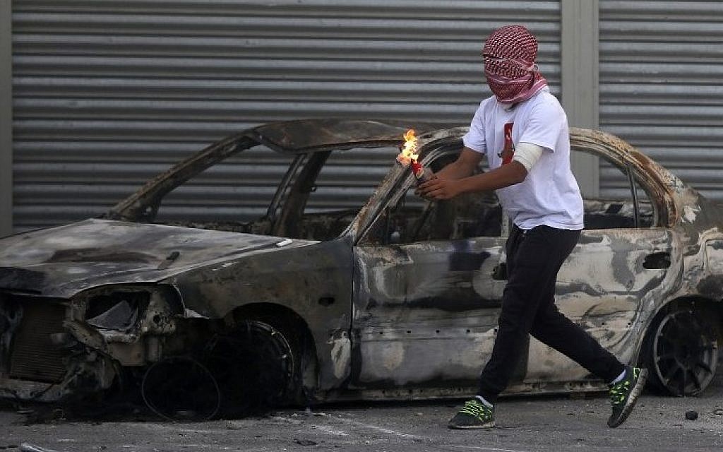 A Palestinian protester prepares to throw a firebomb during clashes with Israeli security forces in the Shuafat refugee camp in East Jerusalem, on October 9, 2015. (Ahmad Gharabli/AFP)