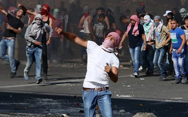 Masked Palestinian protesters clash with Israeli security forces at the Hawara checkpoint, south of the West Bank city of Nablus, on October 11, 2015. (AFP/Jaafar Ashtiyeh) Masked Palestinian protesters clash with Israeli security forces at the Hawara checkpoint, south of the West Bank city of Nablus, on October 11, 2015. (AFP/Jaafar Ashtiyeh)