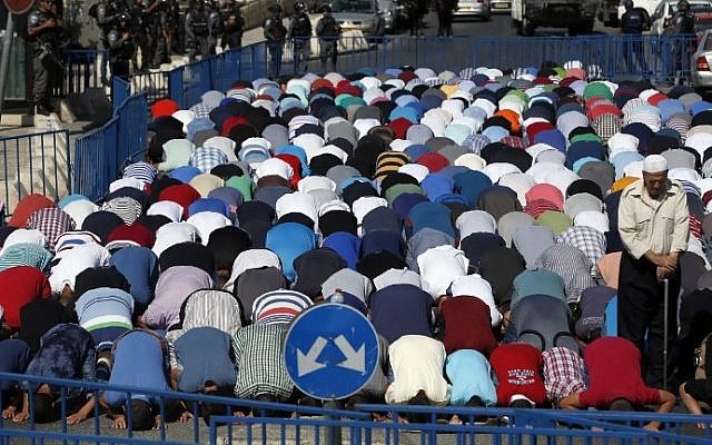 Israeli security forces stand guard as Palestinian Muslim worshipers take part in Friday noon prayers in the Ras al-Amud neighborhood in East Jerusalem, on October 16, 2015, following Israeli restrictions on the Temple Mount. (AFP/ AHMAD GHARABLI)