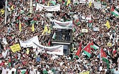 Jordanian protesters wave the national and Palestinian flags during a demonstration near the Israeli Embassy in the capital Amman in solidarity with the Palestinians on October 16, 2015. (Khalil Mazraawi/AFP)