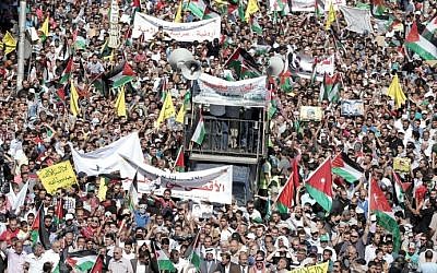 Jordanian protesters wave the national and Palestinian flags during a demonstration near the Israeli Embassy in the capital Amman in solidarity with the Palestinians on October 16, 2015. (Khalil Mazraawi/AFP)
