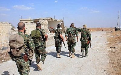 Syrian regime soldiers walk down a road in an area around Kweyris military airport, in the eastern Aleppo province on October 16, 2015. (AFP/George Ourfalian)