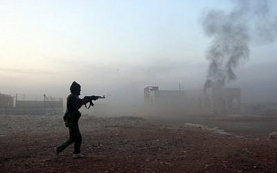 A picture taken on October 17, 2015 shows smoke billowing as a Syrian opposition fighter fires a weapon in the Mount Azzan area, 24 kms from the northern Syrian city of Aleppo, during reported fighting against forces loyal to Syrian President Bashar Assad. (AFP PHOTO/THAER MOHAMMED)
