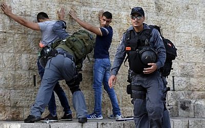 Illustrative: Israeli policemen check Palestinian youths at Damascus Gate in the Old City of Jerusalem on October 18, 2015. (AFP/Ahmad Gharabli)